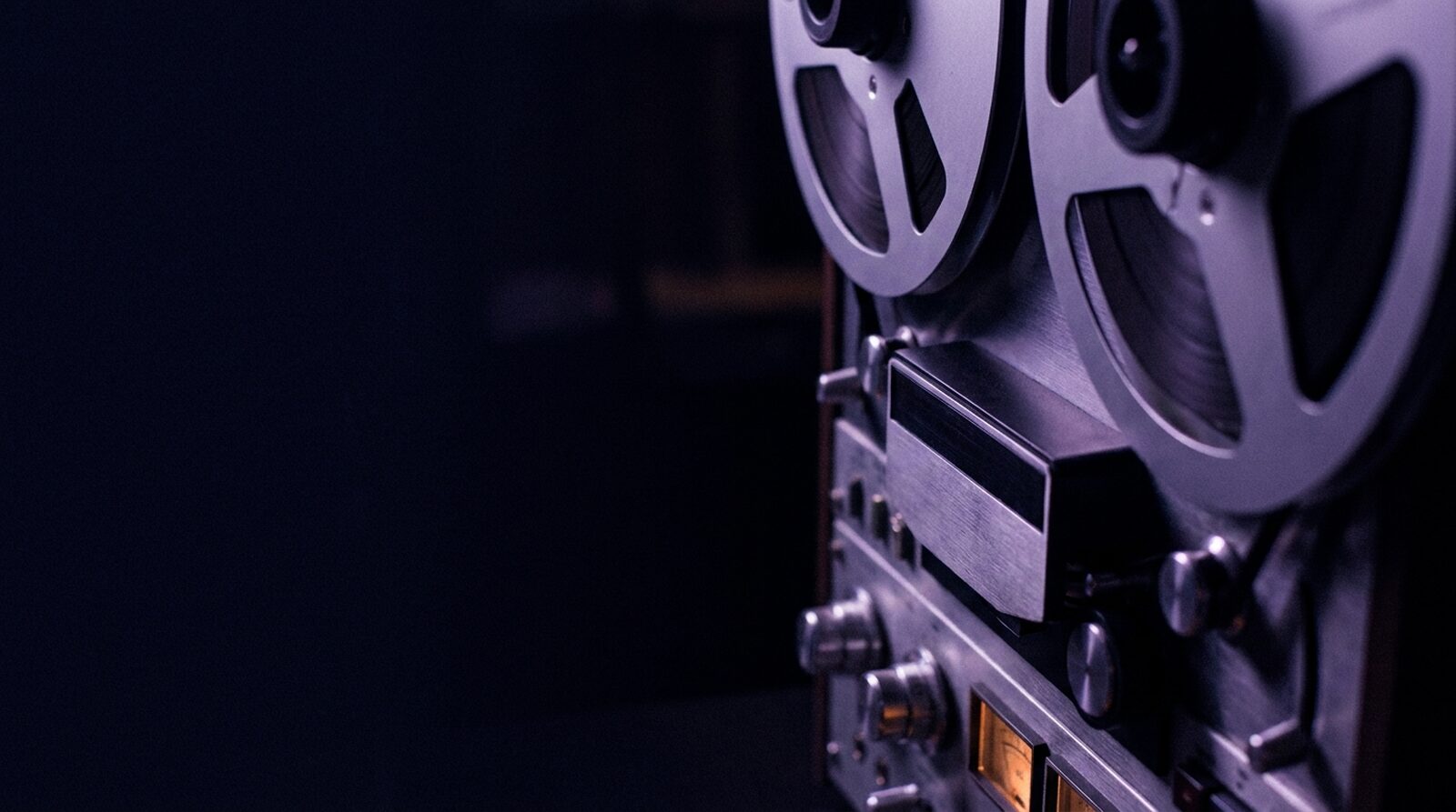 Reel-to-reel tape machine in a dimly lit studio